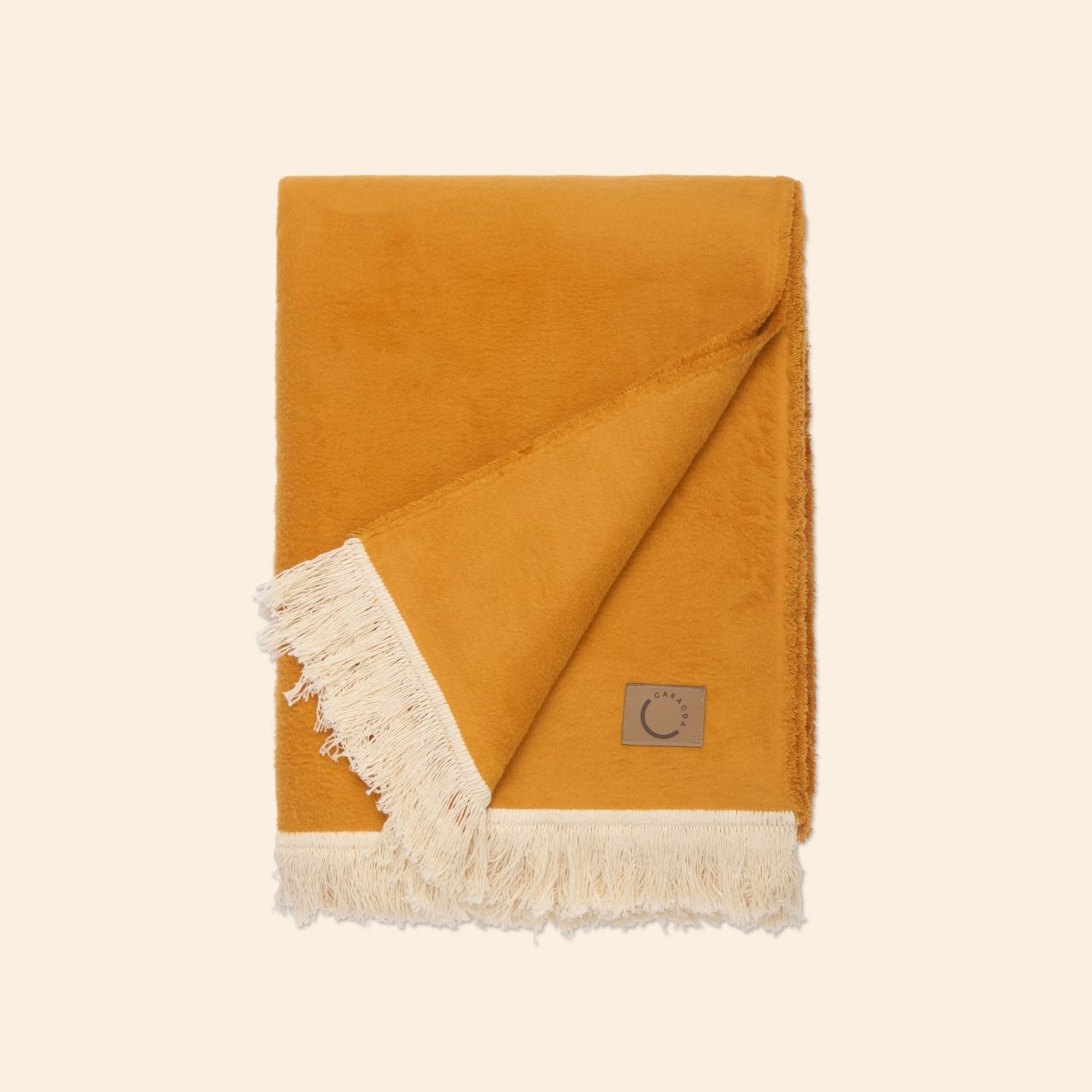 Kuscheldecke aus Baumwolle mit Fransen in Ockerorange (Gefaltet)