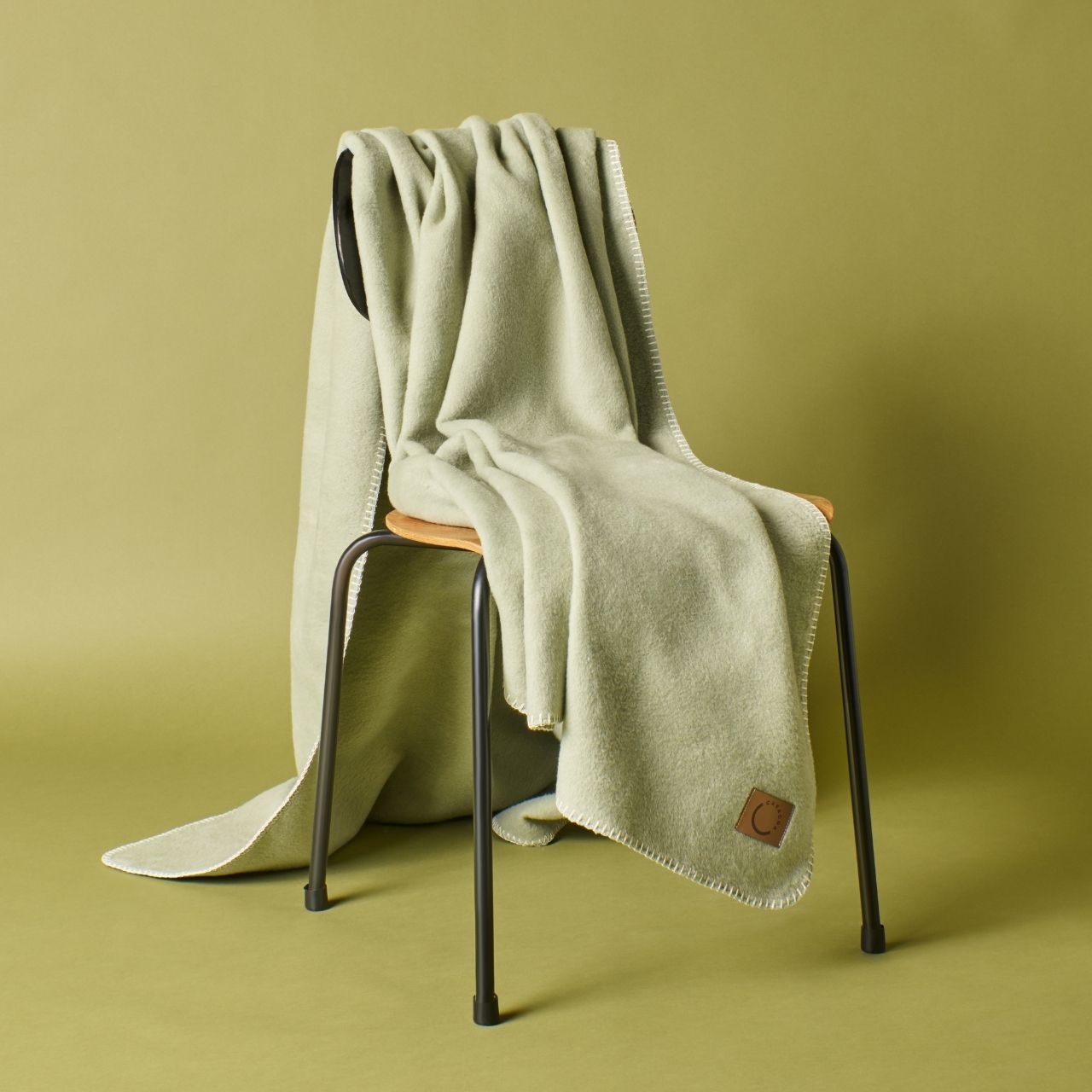 Kuscheldecke aus Baumwolle in Lindgrün (Stuhlansicht)