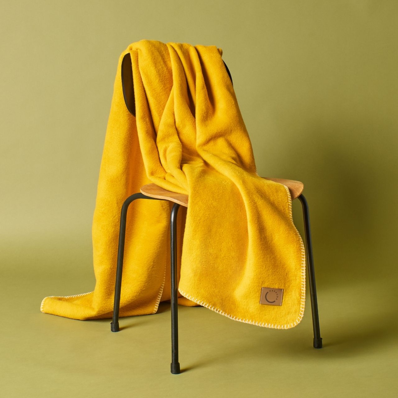Kuscheldecke aus Baumwolle in Ockergelb (Stuhlansicht)