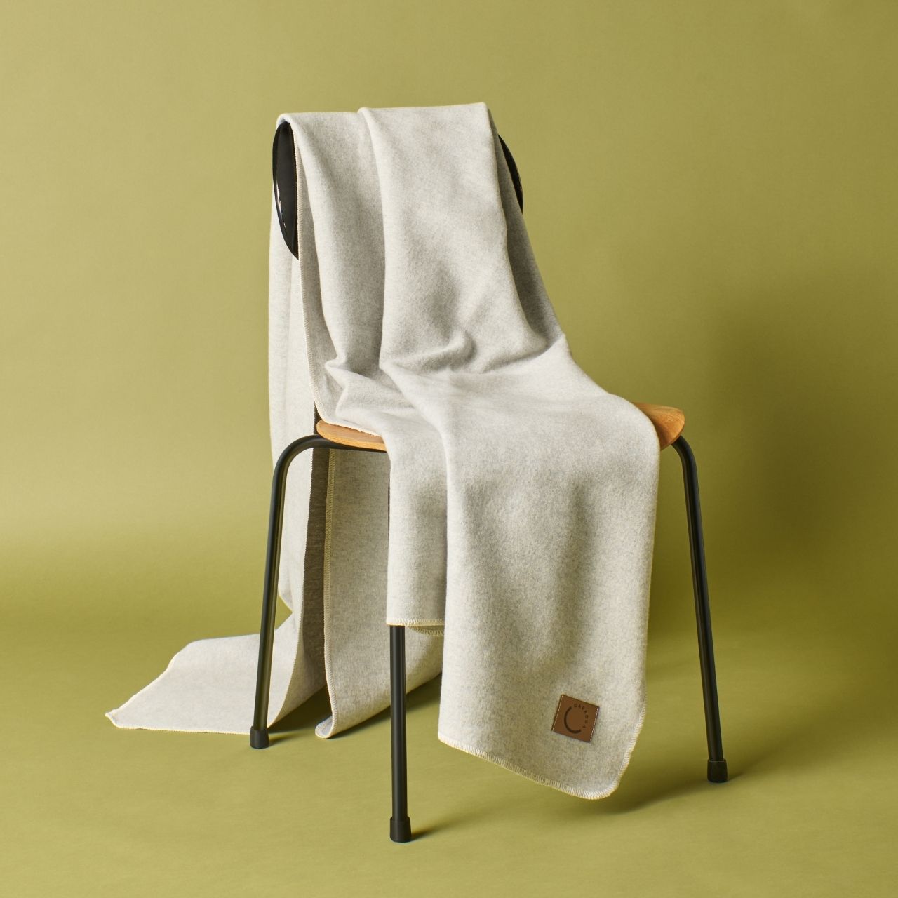 Kuscheldecke aus Baumwolle in Hellgrau (Stuhlansicht)